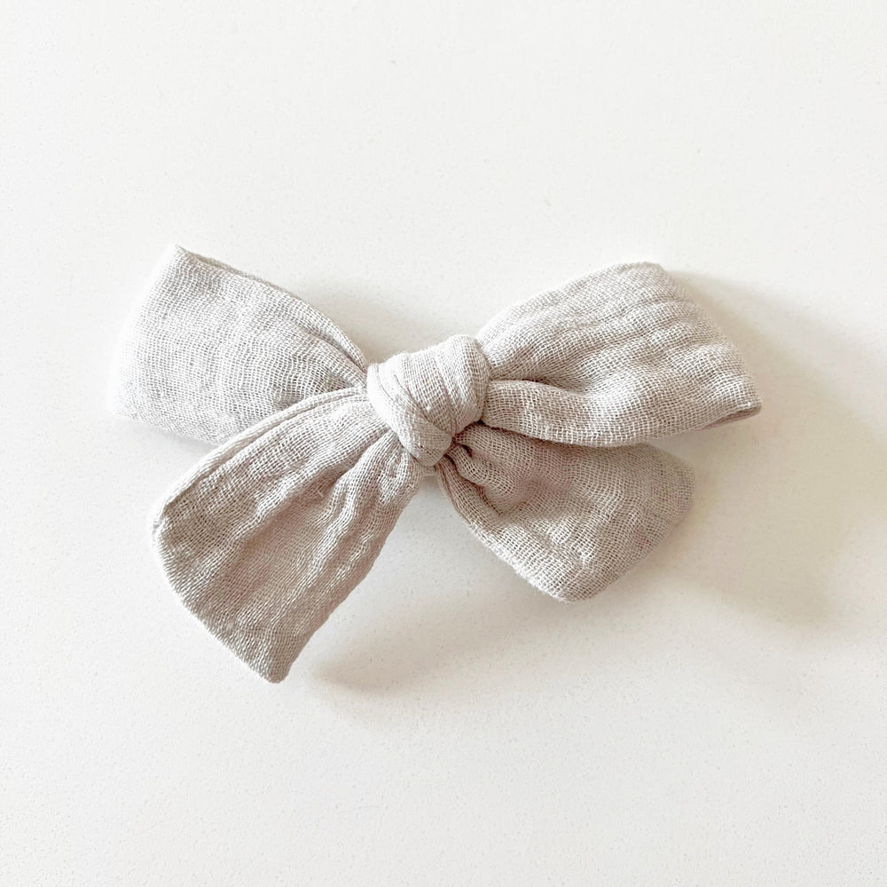 
            
                Load image into Gallery viewer, Greige Muslin Bow with Clip - BohemianBabies
            
        
